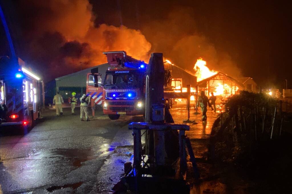 Brandweer bestrijdt grote uitslaande brand in twee loodsen