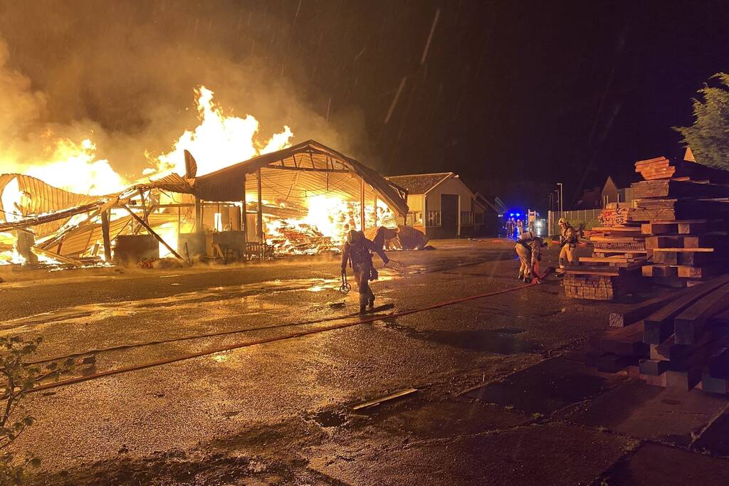 Brandweer bestrijdt grote uitslaande brand in twee loodsen