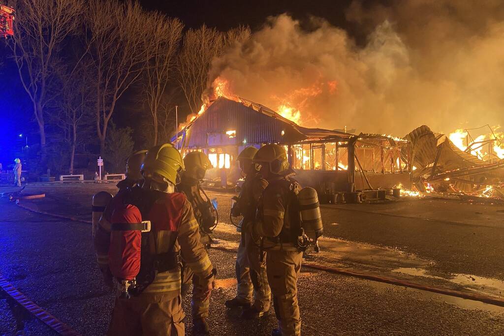 Brandweer bestrijdt grote uitslaande brand in twee loodsen