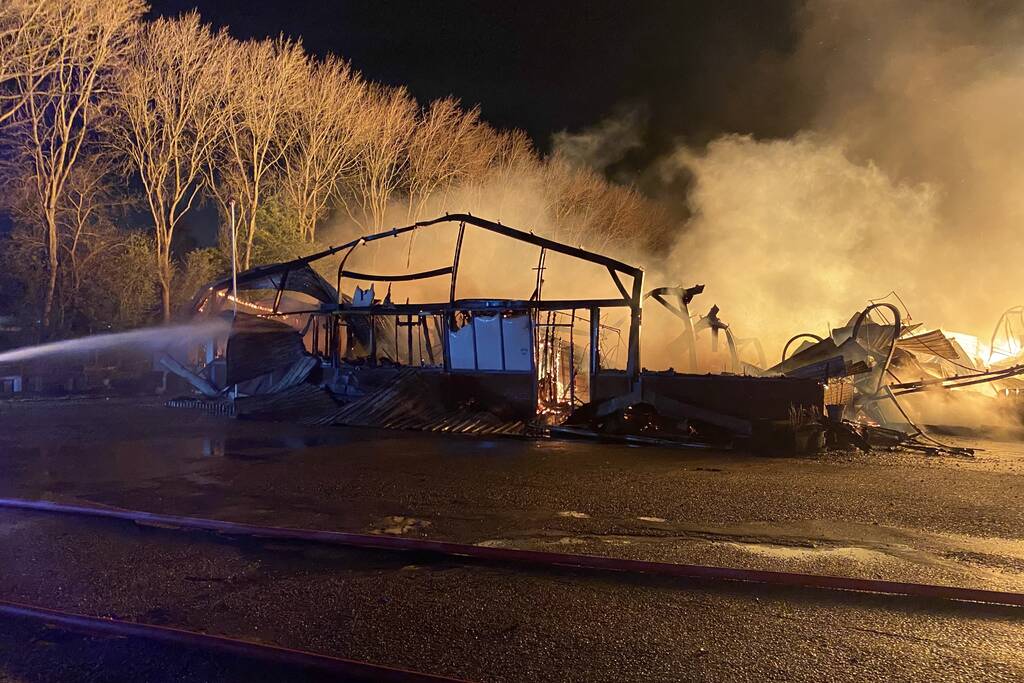 Brandweer bestrijdt grote uitslaande brand in twee loodsen