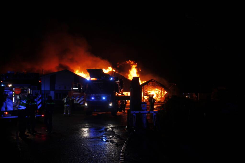 Brandweer bestrijdt grote uitslaande brand in twee loodsen