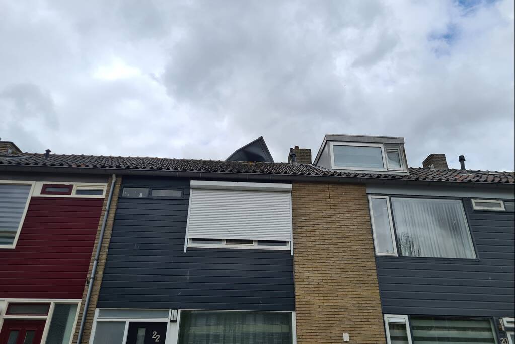 Dakbedekking waait van dakkapel van woning
