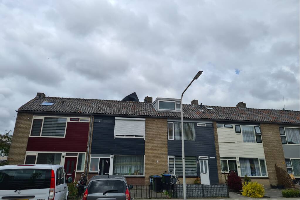 Dakbedekking waait van dakkapel van woning