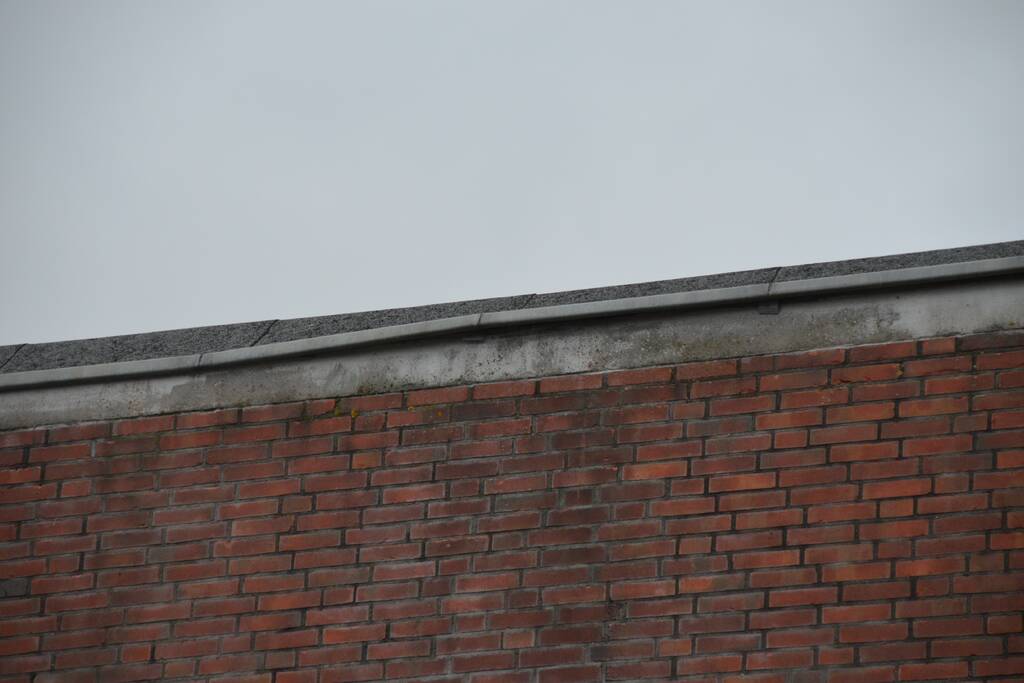 Brandweer boort schroeven in bijna loskomende dakrand