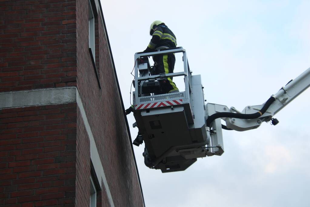 Brandweer boort schroeven in bijna loskomende dakrand