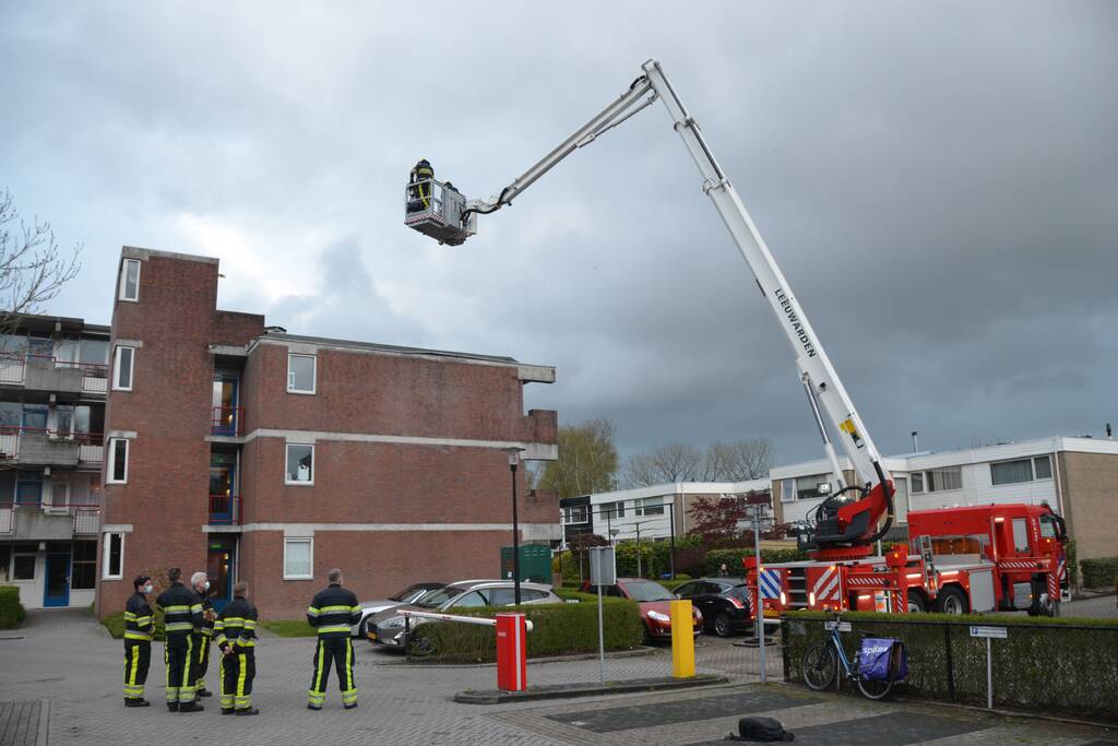 Brandweer boort schroeven in bijna loskomende dakrand