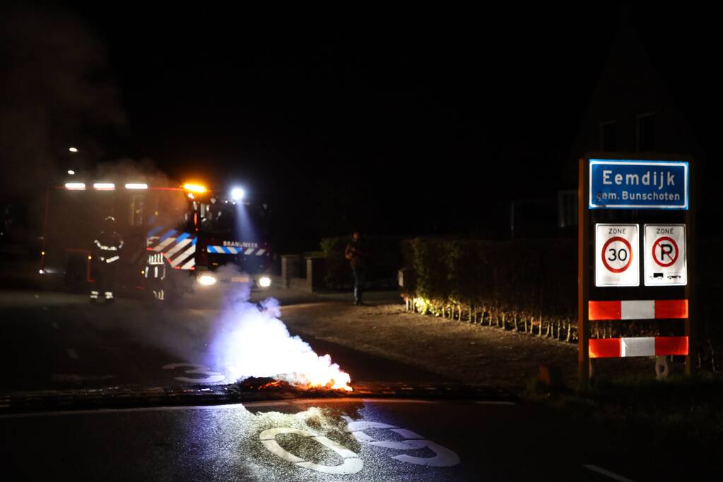 Brandweer blust brandende band op midden van weg
