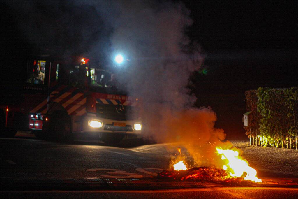 Brandweer blust brandende band op midden van weg