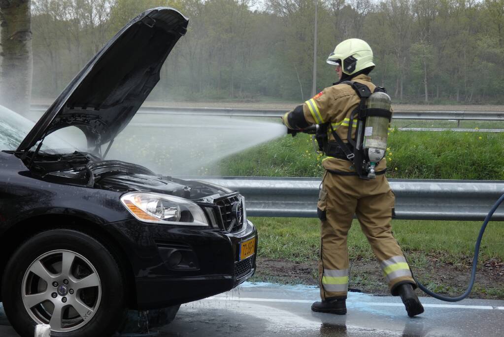 Brandweer blust brand in motorcompartiment van personenauto
