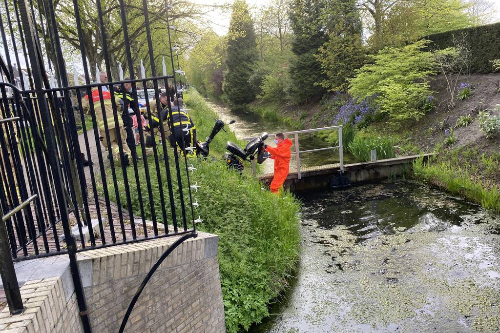 Persoon rijdt met scootmobiel het water in