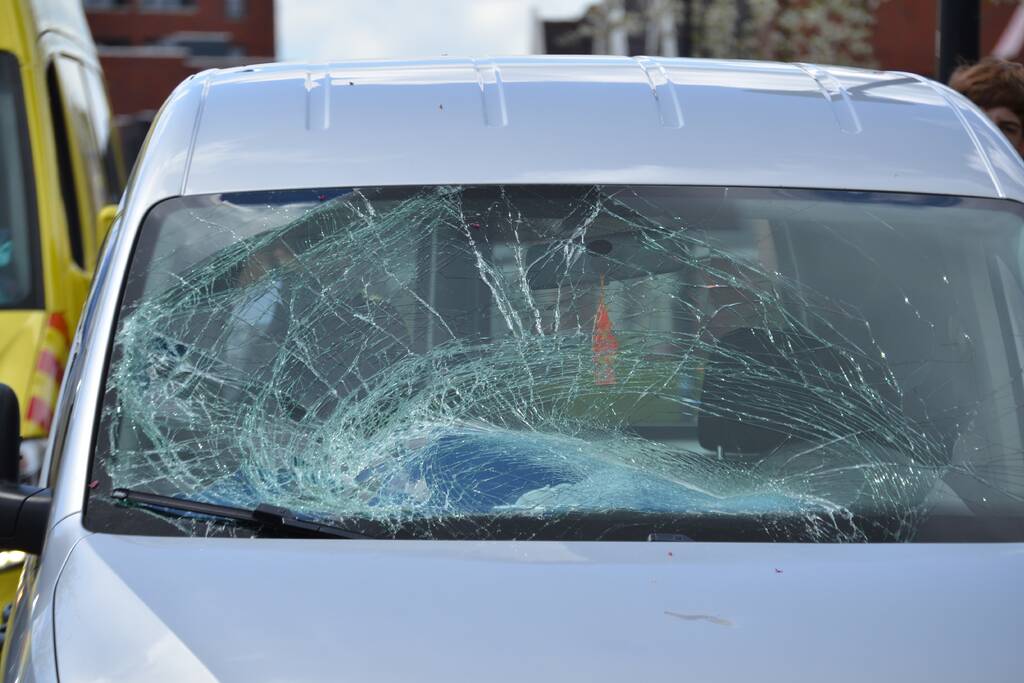 Fietser geschept door bestelwagen op kruising