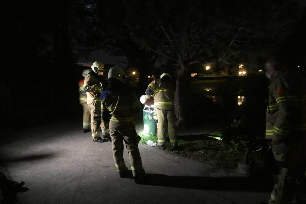 Brandweer blust brand in prullenbak