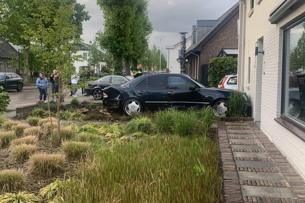 Auto rijdt door voortuin en tegen woning
