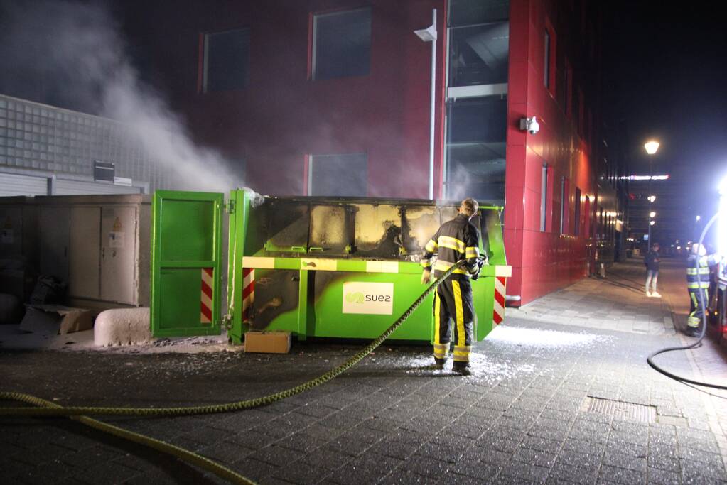 Bouwcontainer vol papier vat vlam