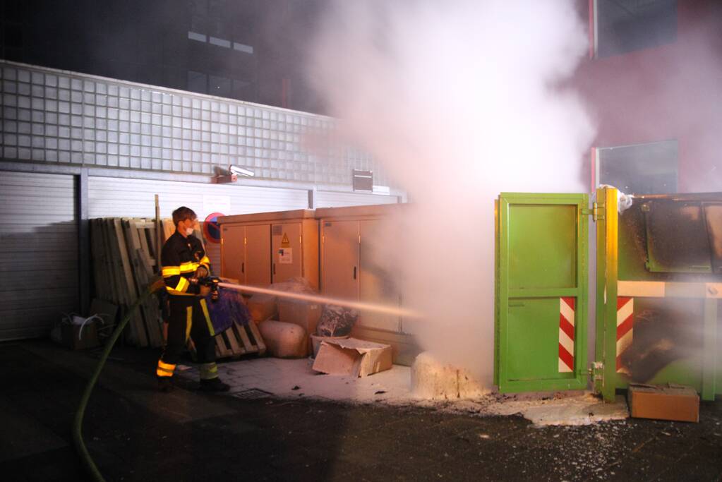 Bouwcontainer vol papier vat vlam