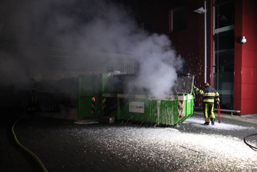 Bouwcontainer vol papier vat vlam