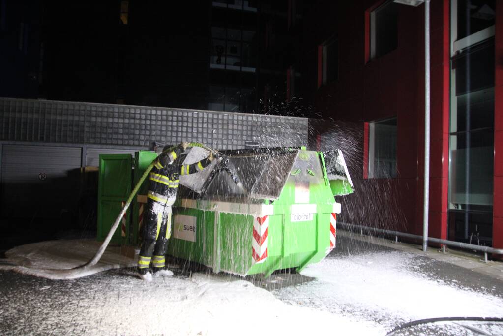 Bouwcontainer vol papier vat vlam