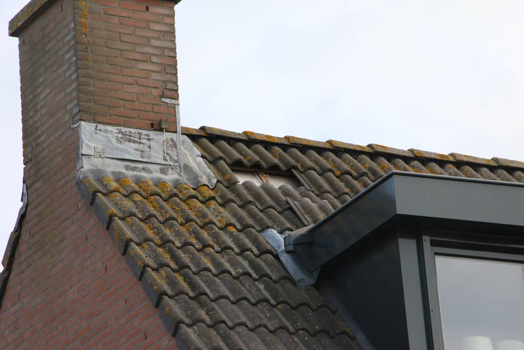 Brandweer legt weggewaaide dakpannen terug