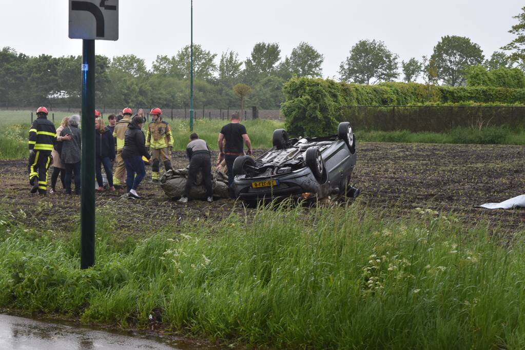 Auto op z'n kop in weiland