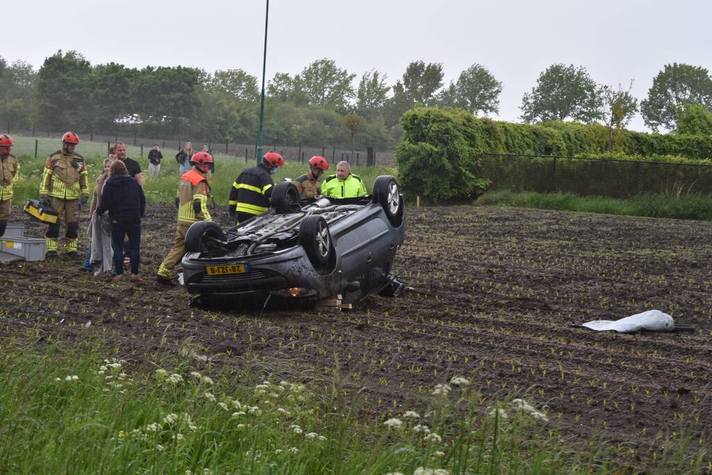 Auto op z'n kop in weiland