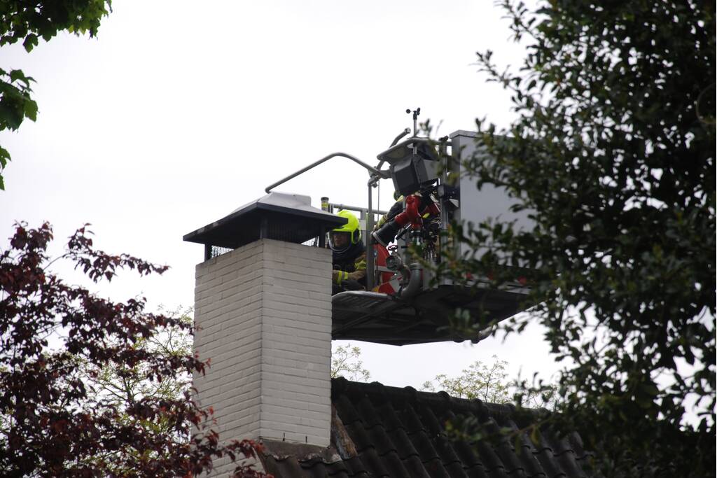Brandweer blust brand in schoorsteen