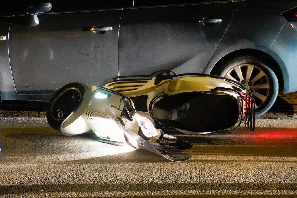 Scooterrijder gaat onderuit en beschadigd twee auto's