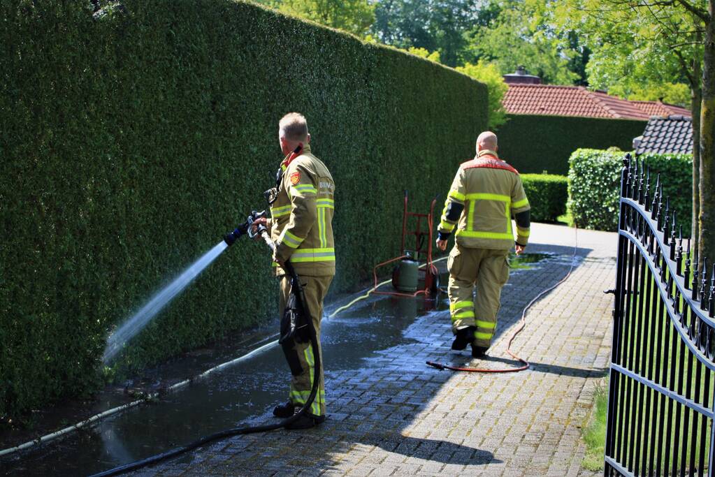Coniferenhaag in brand door onkruid verbranden