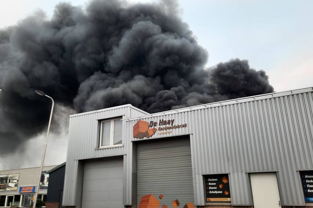 Dikke zwarte rookwolken bij uitslaande brand