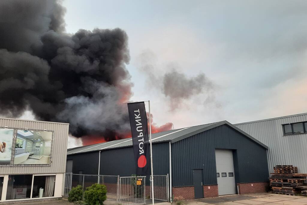 Dikke zwarte rookwolken bij uitslaande brand