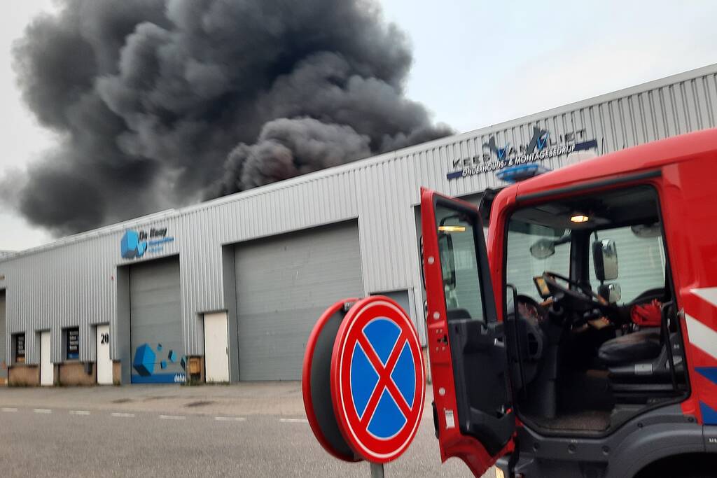 Dikke zwarte rookwolken bij uitslaande brand