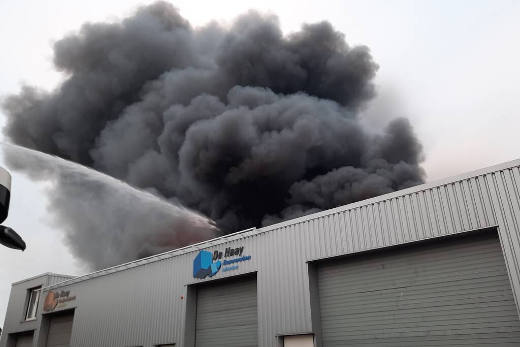 Dikke zwarte rookwolken bij uitslaande brand
