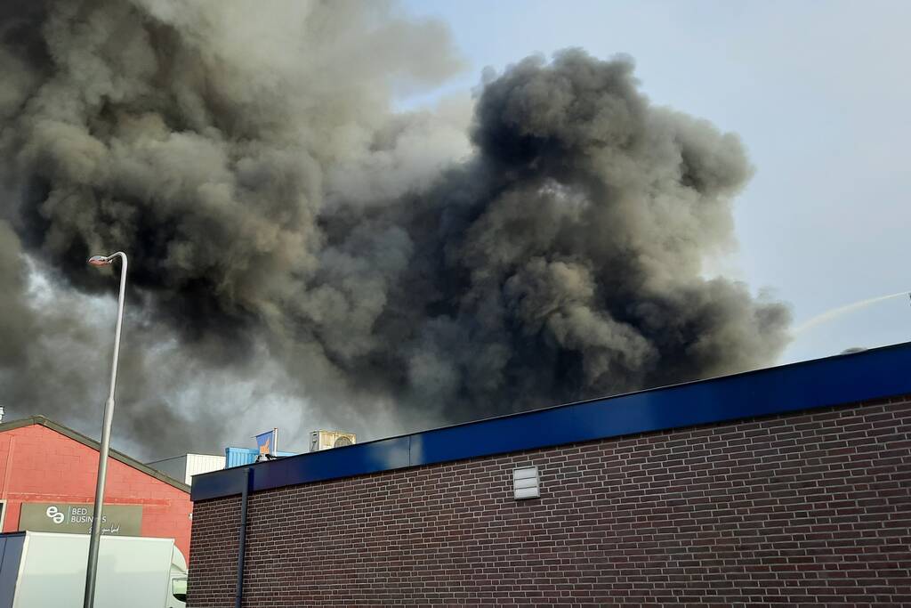 Dikke zwarte rookwolken bij uitslaande brand