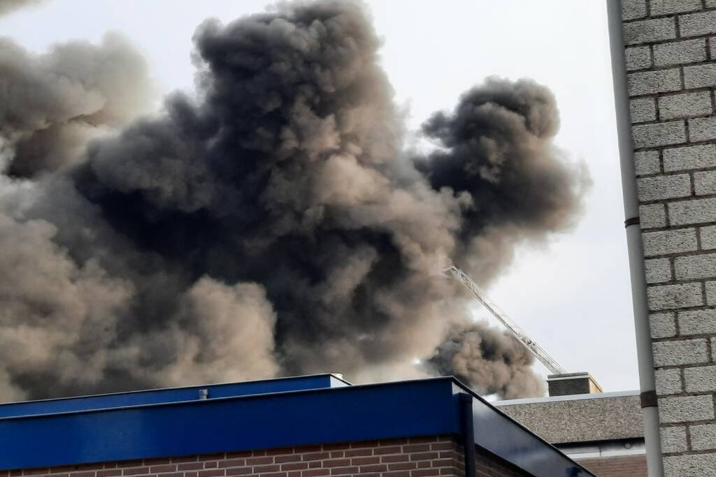 Dikke zwarte rookwolken bij uitslaande brand