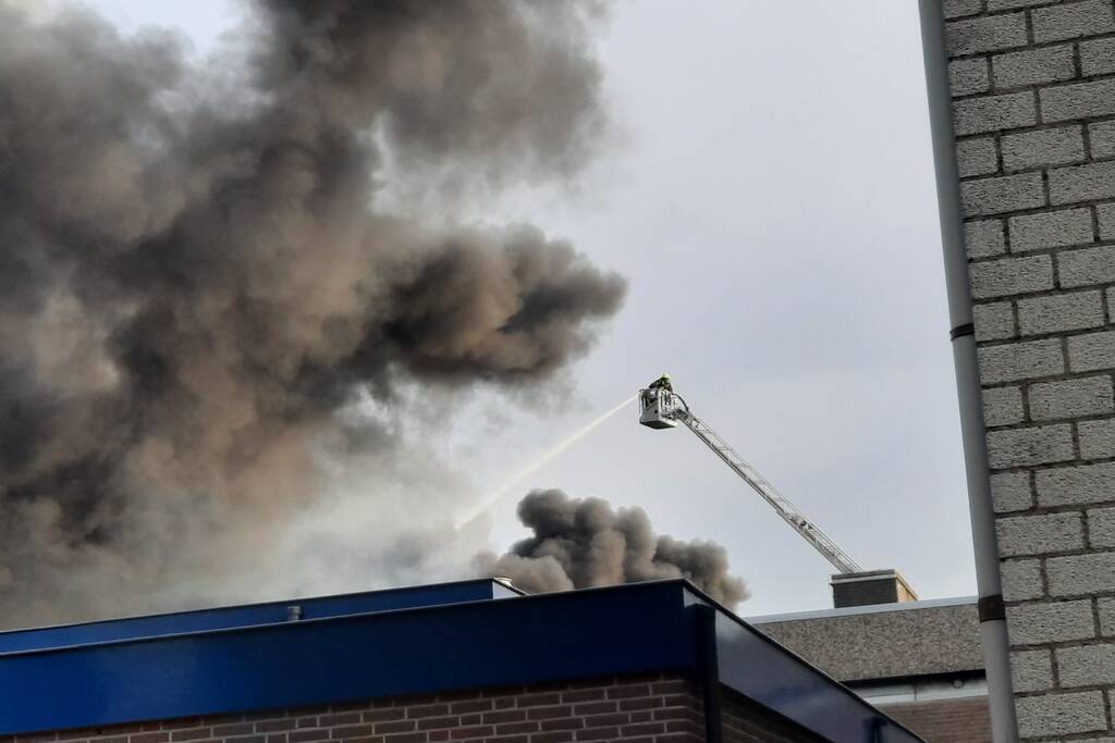 Dikke zwarte rookwolken bij uitslaande brand