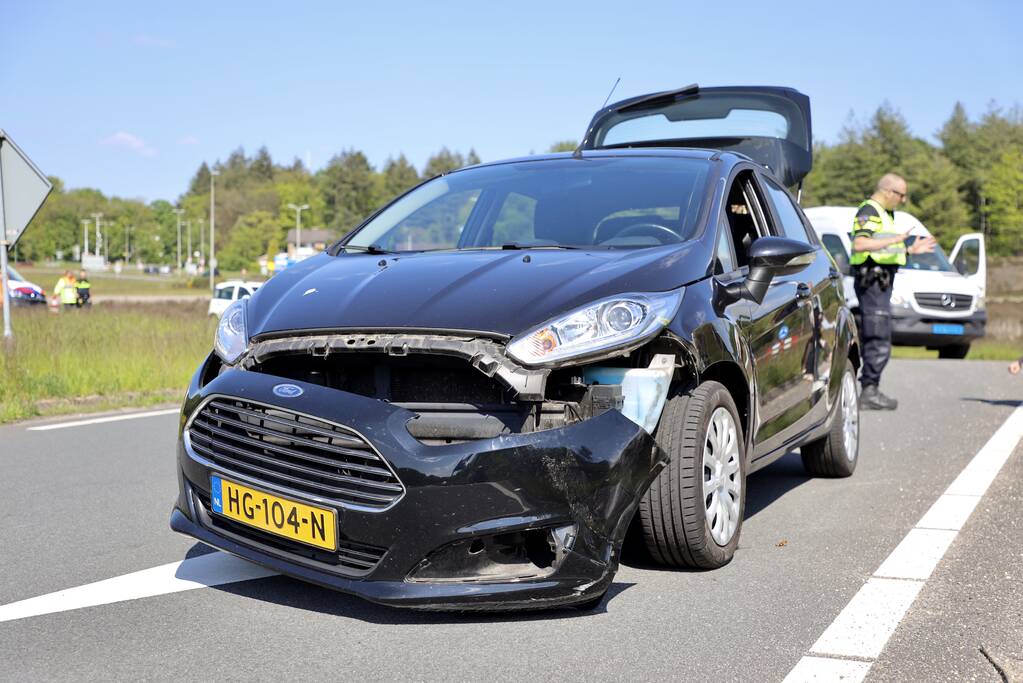 Auto botst op taxibus op rotonde