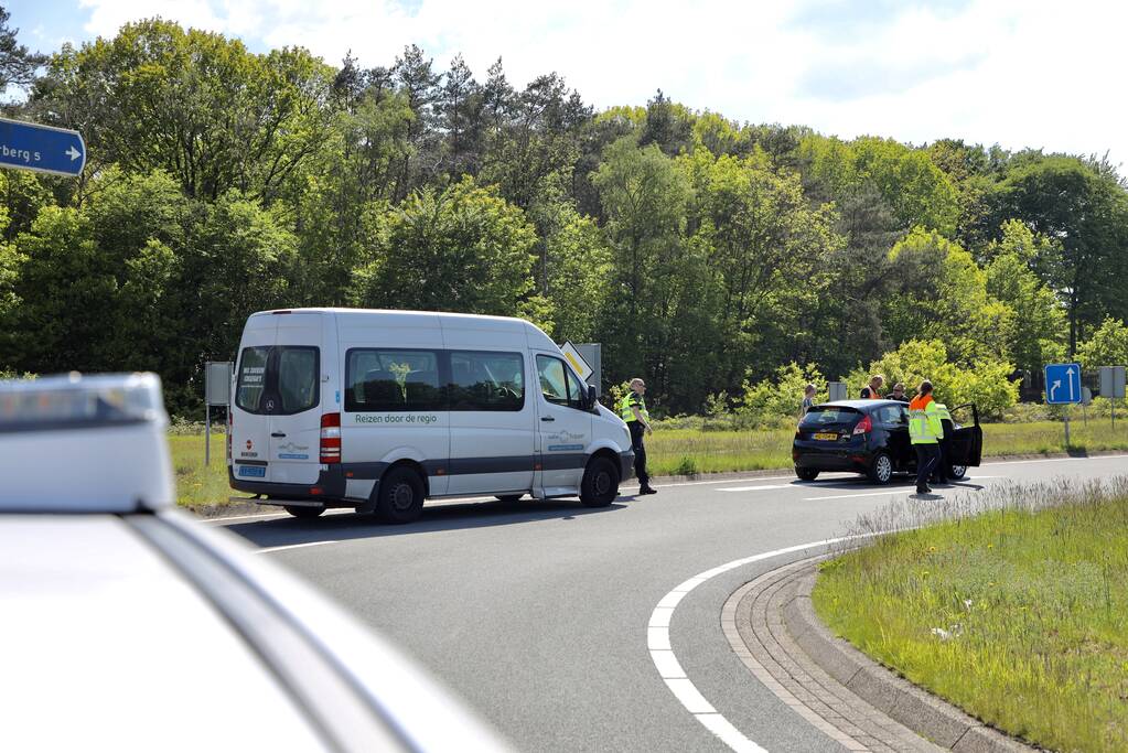 Auto botst op taxibus op rotonde
