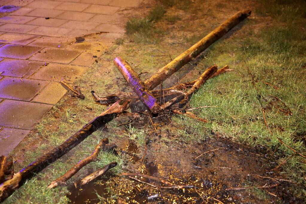 Brandweer blust brandende stukken hout