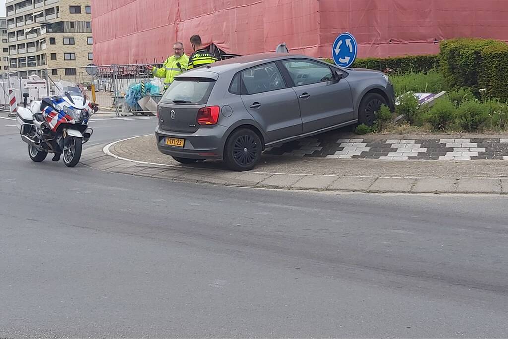 Automobilist rijdt met auto de rotonde op