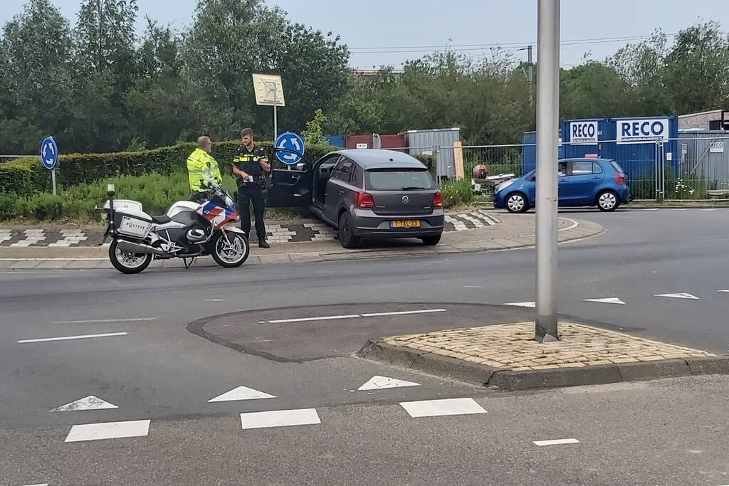Automobilist rijdt met auto de rotonde op