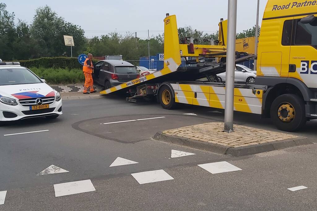 Automobilist rijdt met auto de rotonde op