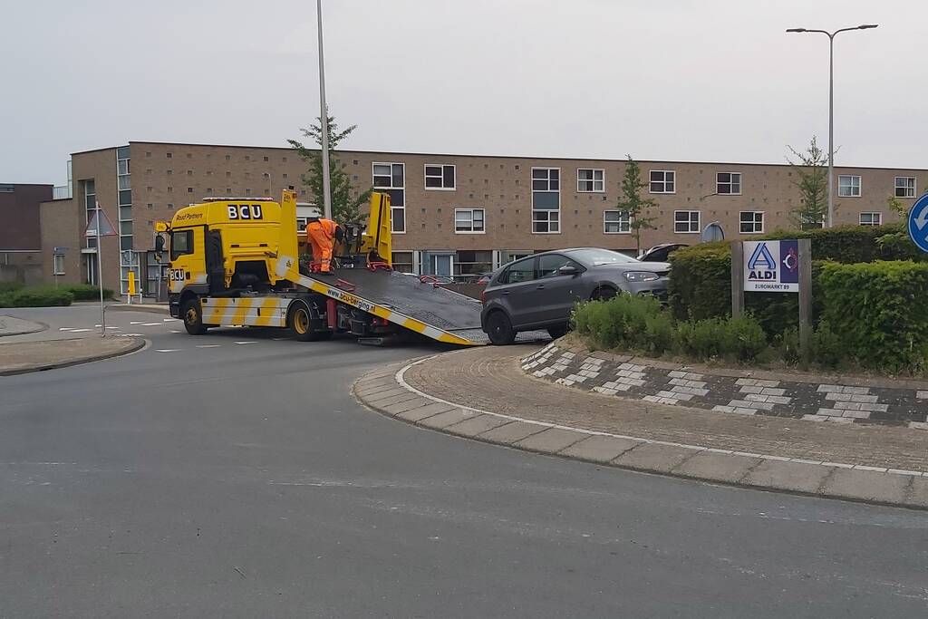 Automobilist rijdt met auto de rotonde op