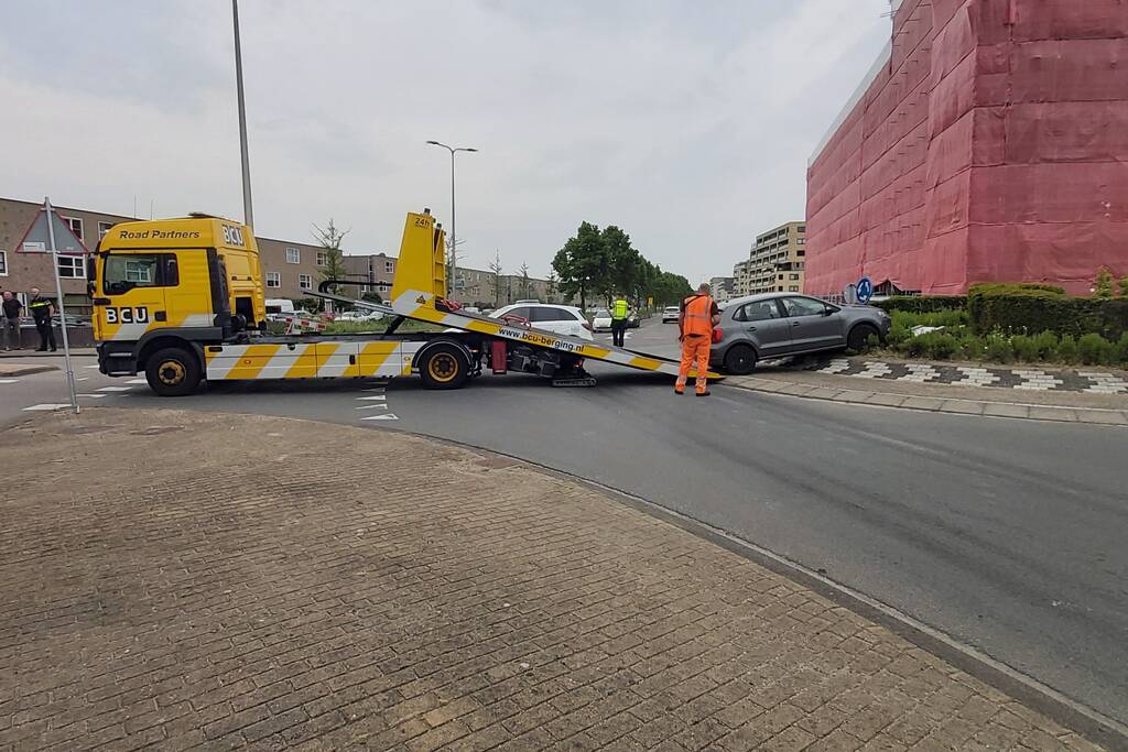 Automobilist rijdt met auto de rotonde op
