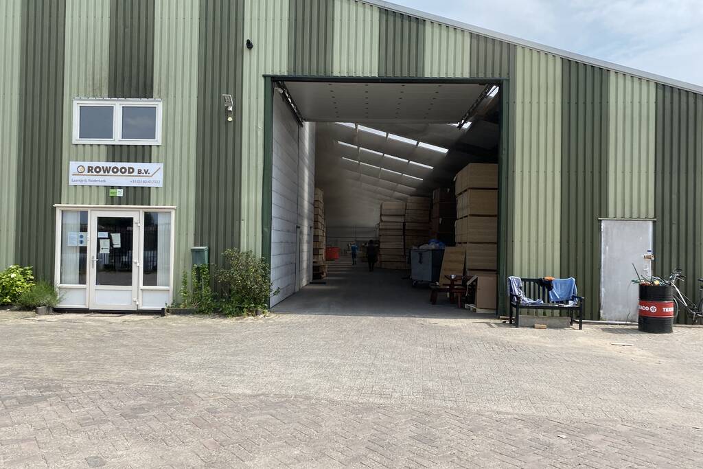 Brandweer blust brandende container met houtpulp bij houtbedrijf Rowood