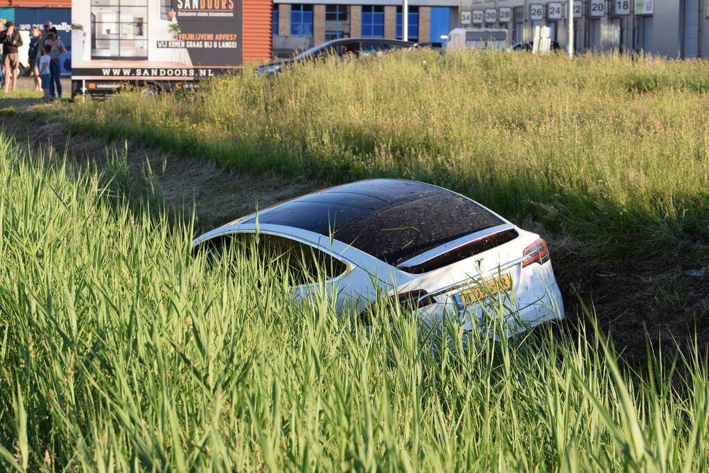 Bestuurder van Tesla verliest macht over het stuur en belandt in sloot