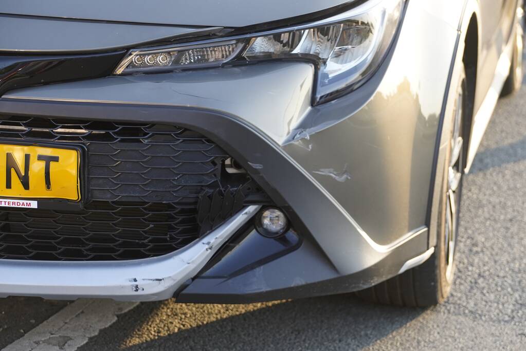 Personenauto en motor botsen op rotonde