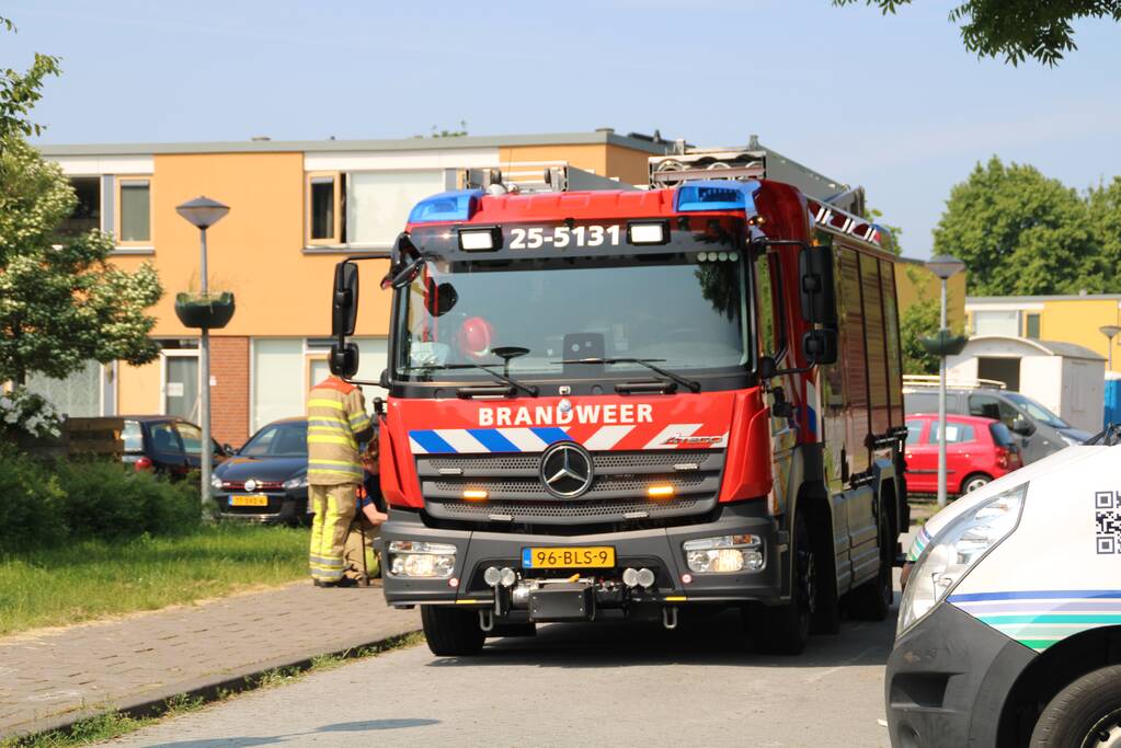 Brandweer blust in brand staande schutting