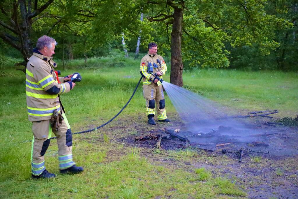 Stapel houten takken in brand in bosgebied De Bergjes