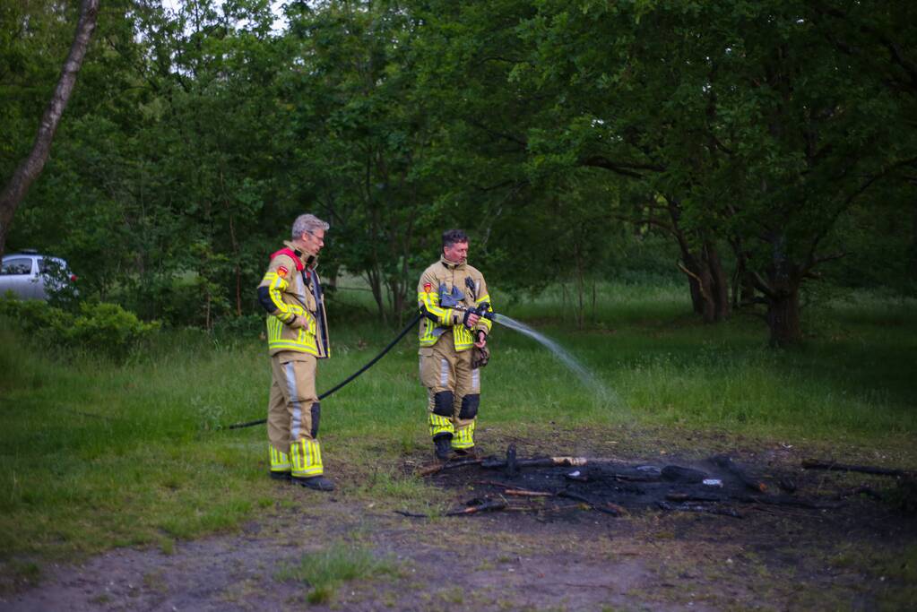 Stapel houten takken in brand in bosgebied De Bergjes