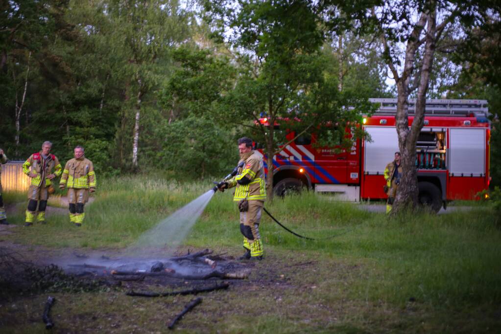 Stapel houten takken in brand in bosgebied De Bergjes