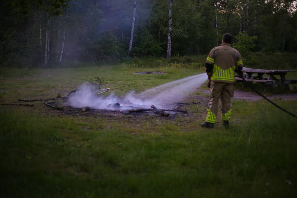 Stapel houten takken in brand in bosgebied De Bergjes